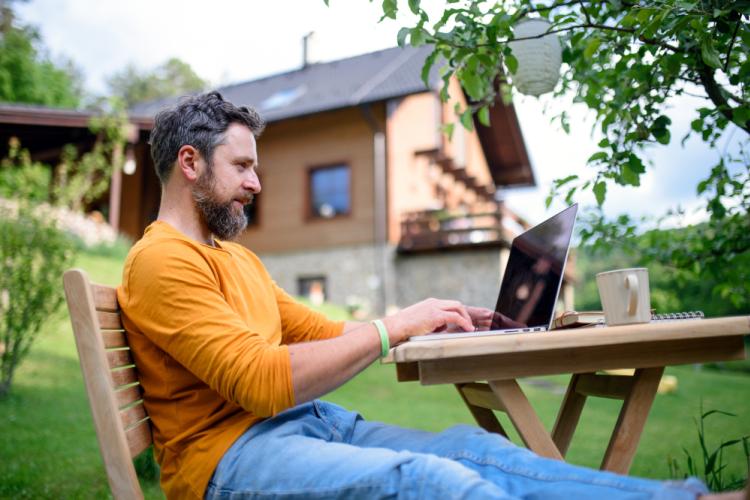 homme travaillant sur son pc dans son jardin